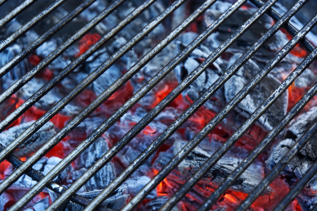 Close-up shot of the Uniflame Portable Grill showing its stainless steel construction and grilling f