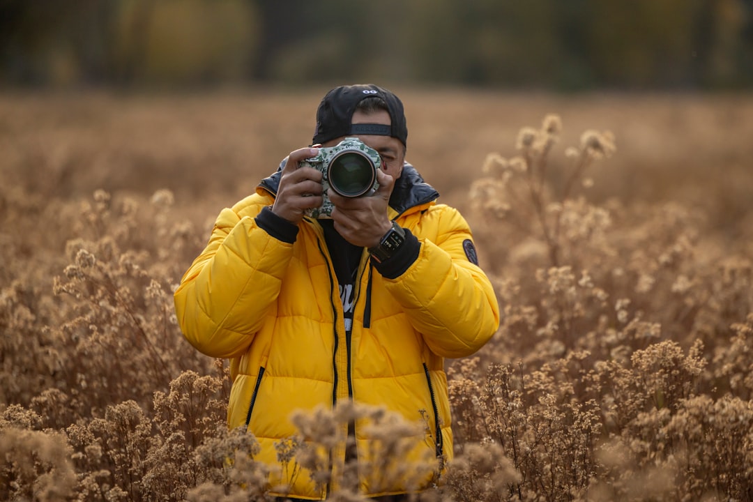 A dynamic landscape shot featuring a photographer using both cameras in an outdoor setting, showcasi