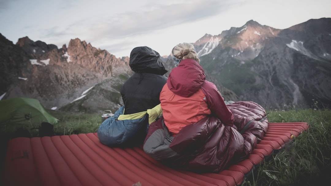 A stunning outdoor scene featuring both Montbell and Nanga sleeping bags set up in nature, with a ca