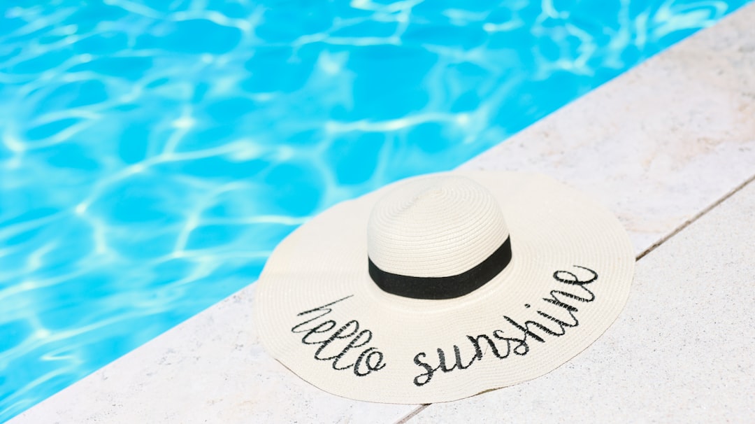 An image showcasing multiple sunscreen products arranged aesthetically on a beach towel, with summer