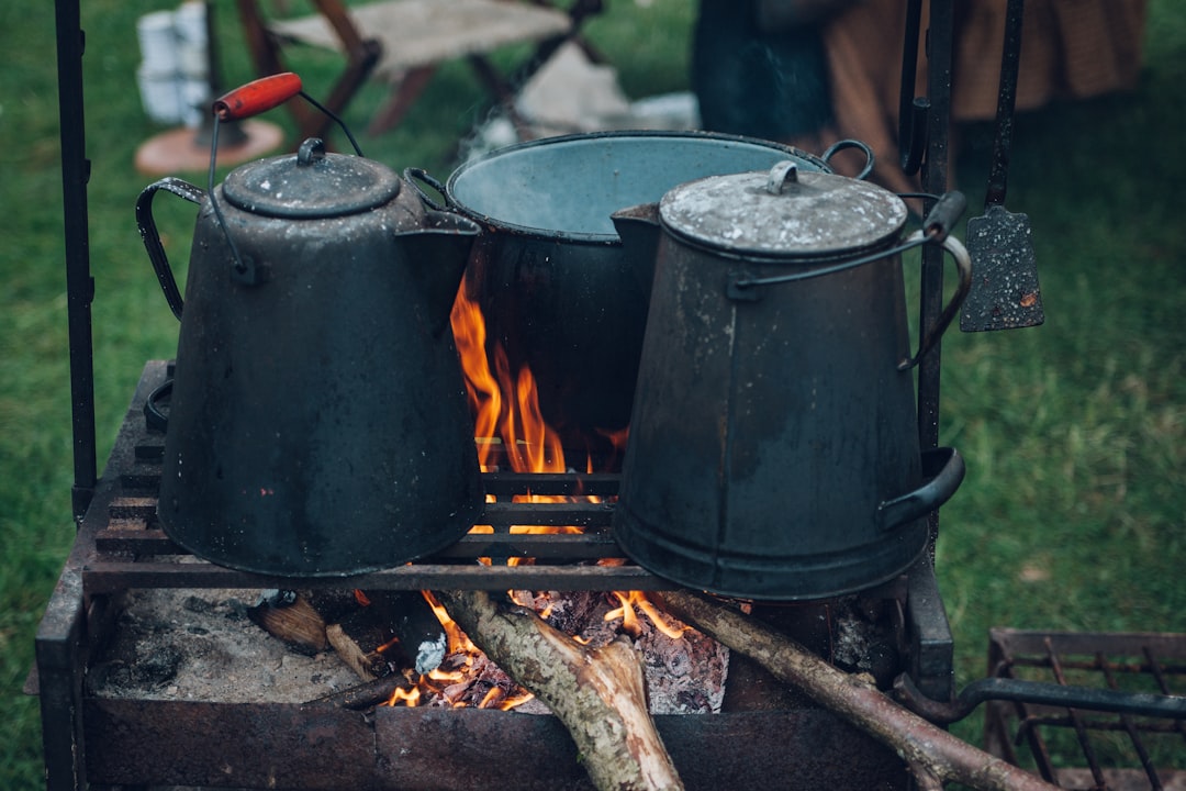 An image showcasing the Soto WindMaster Stove in action, boiling water or cooking food over a campfi