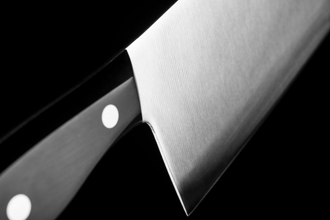A close-up shot of a hand demonstrating the sharpening technique, with a knife held at the correct a
