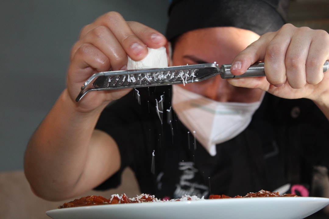 A chef using a Yoshihiro Santoku knife to chop vegetables on a cutting board, illustrating its ergon