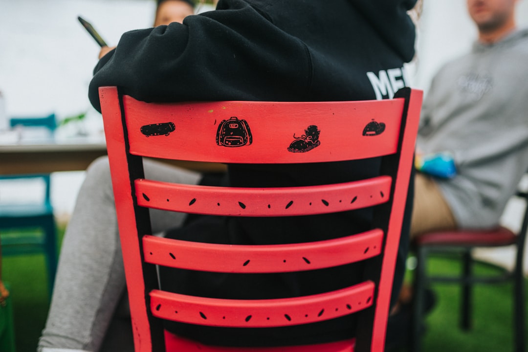 An image of a lightweight folding Captain Stag chair being packed into a backpack for a hiking trip.