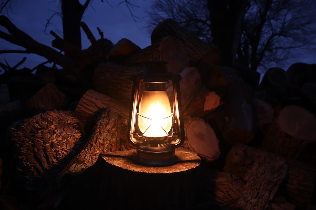 A stunning outdoor scene featuring both Uniflame and Soto camping lanterns lit up at night, surround