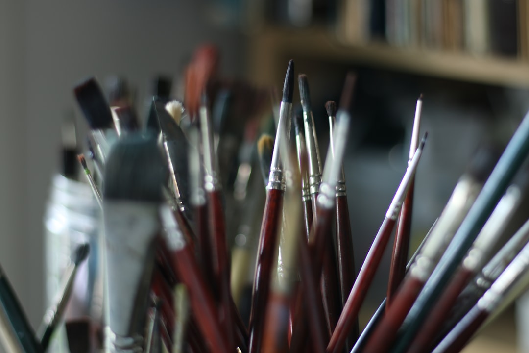 A flat lay image of the Pentel P205, Pentel Sharp, and a sketchbook, showing each pencil with their