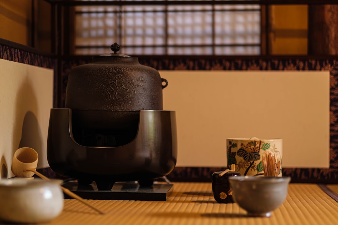 A close-up image of the Iwachu Cast Iron Teapot, beautifully styled with tea leaves and tea cups aro