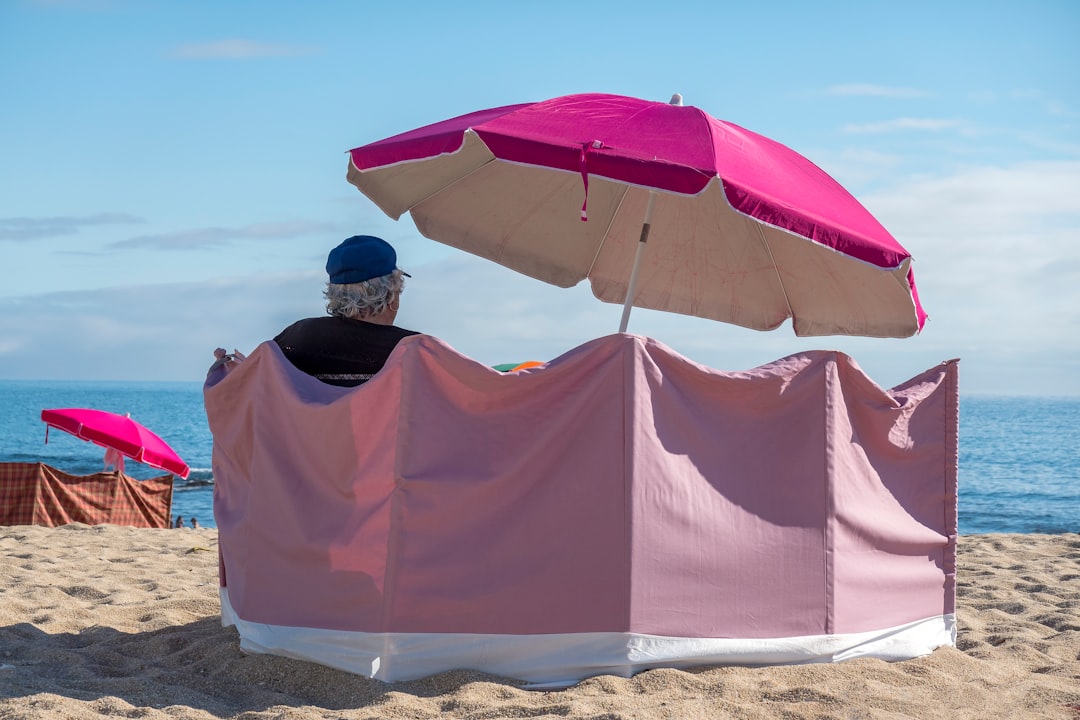 A vibrant outdoor scene featuring both Shiseido and Kanebo sunscreen products displayed on a beach t