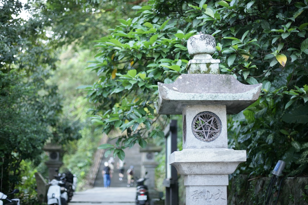An up-close shot of a traditional Japanese stone lantern placed in a natural setting, illustrating i