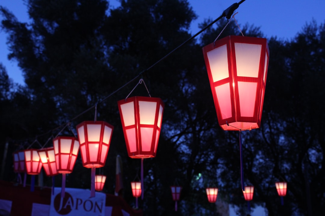 A serene campsite illuminated by various Japanese lanterns at dusk, showcasing their beauty and ambi