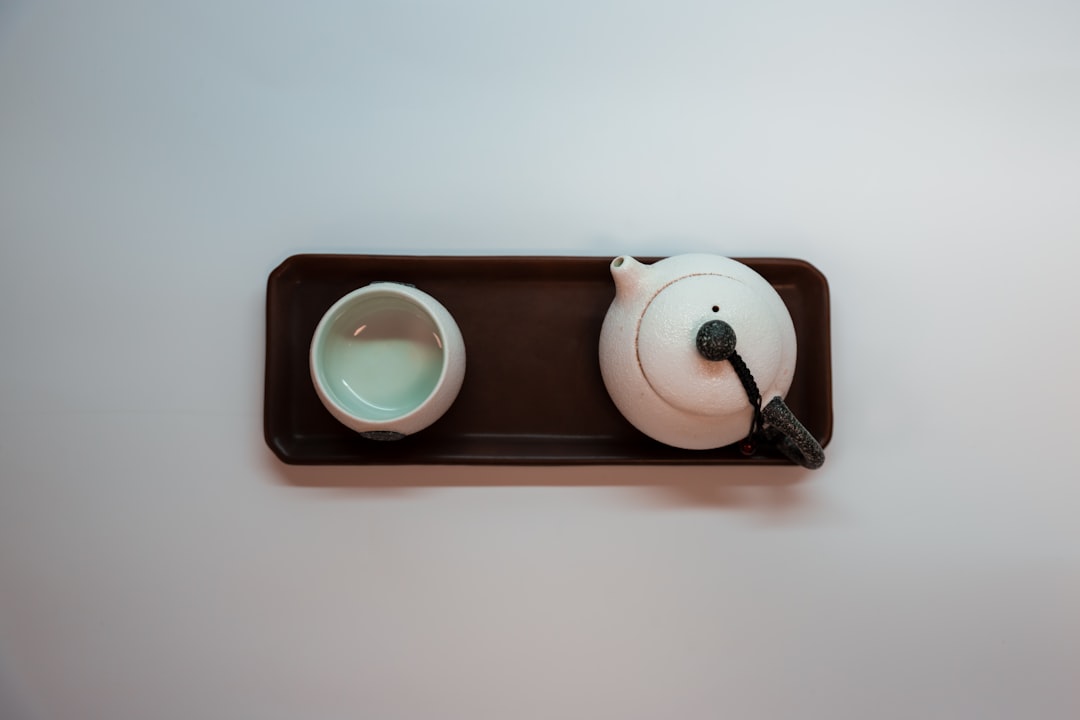 A minimalist shot of Kinto's Cast Iron Teapot with a simple, modern kitchen background that emphasiz