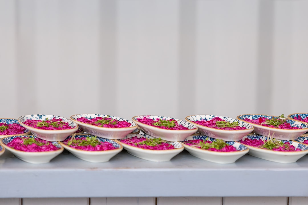 A display of Arita-yaki bowls with hand-painted designs, filled with colorful fresh salads.