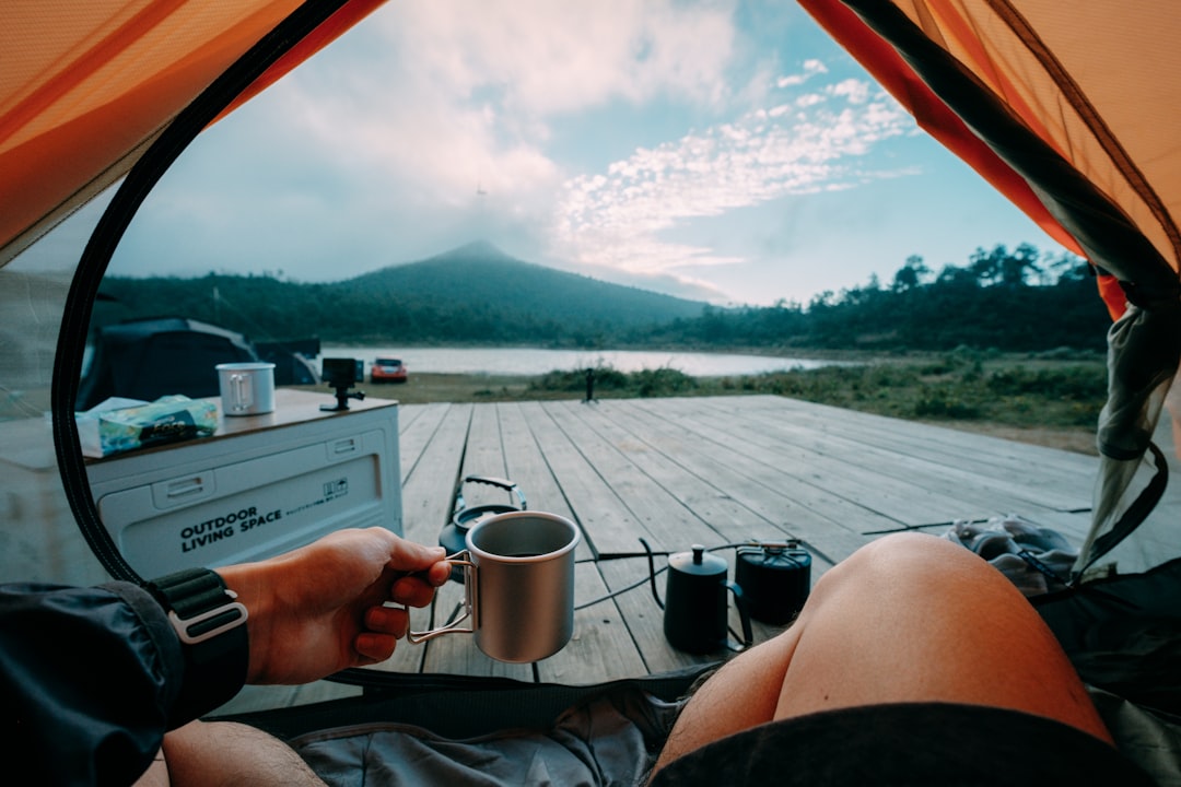 A scenic image featuring a Hario V60 and Kalita Wave coffee makers set up outdoors amidst nature, wi