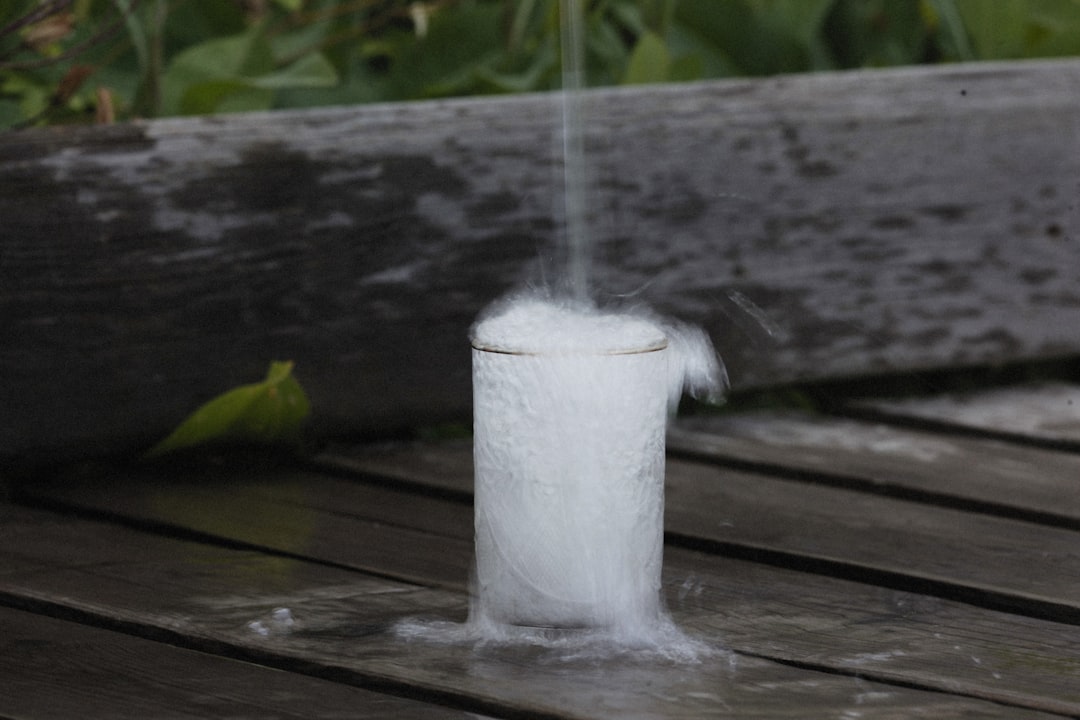 A close-up shot of a person applying Kose's Sekkisei moisturizer on their face in an outdoor setting