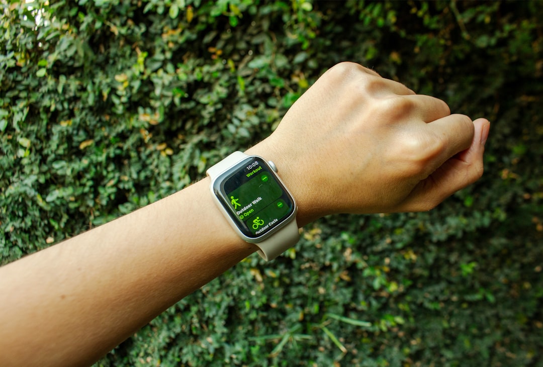A sleek Panasonic smartwatch displayed on a wrist in an outdoor setting, suggesting active use for f