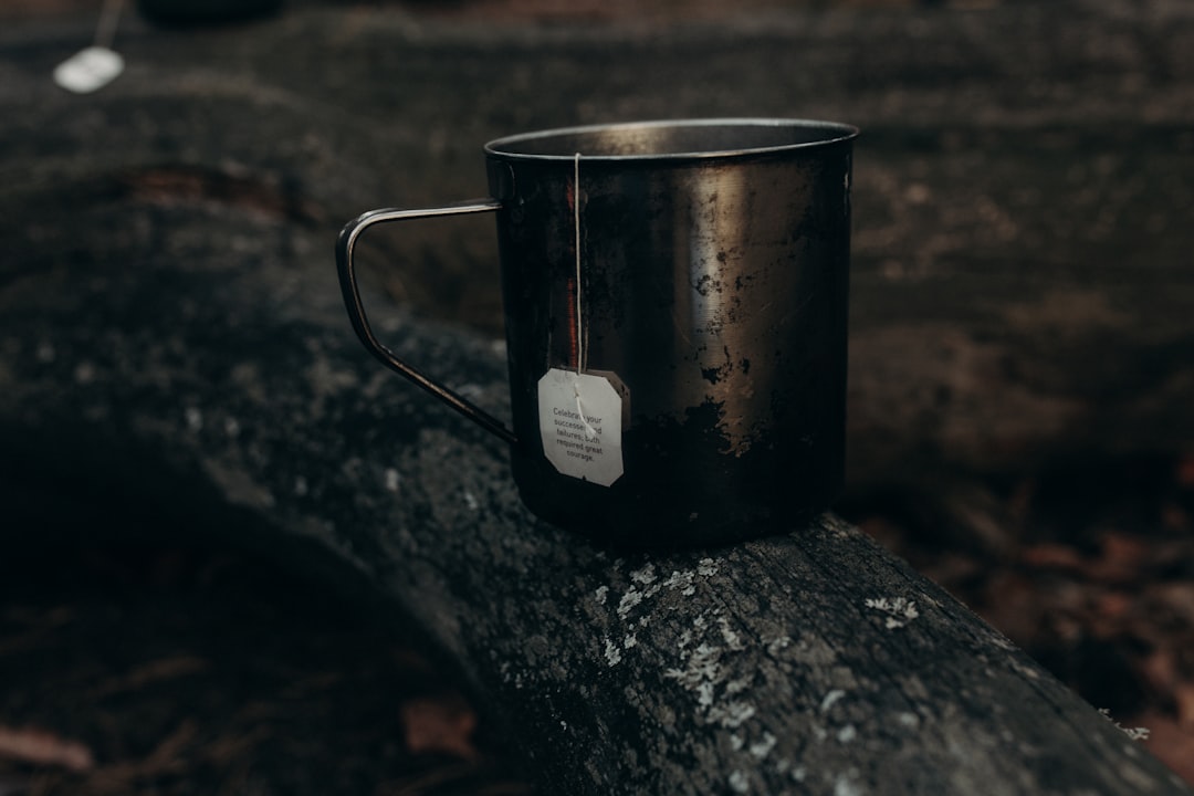 Product shot of the Hario Cold Brew Coffee Pot on a wooden picnic table with ice cubes and a glass o