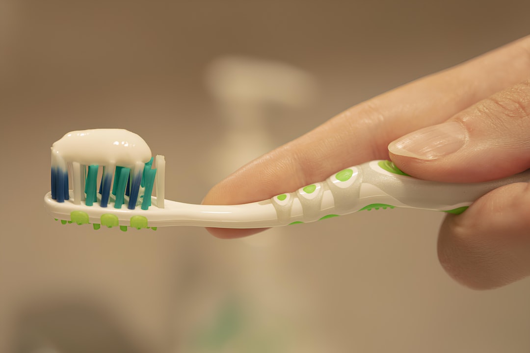 Product-focused image of the Panasonic EW-BU12 Bluetooth wearable device attached to a toothbrush, i