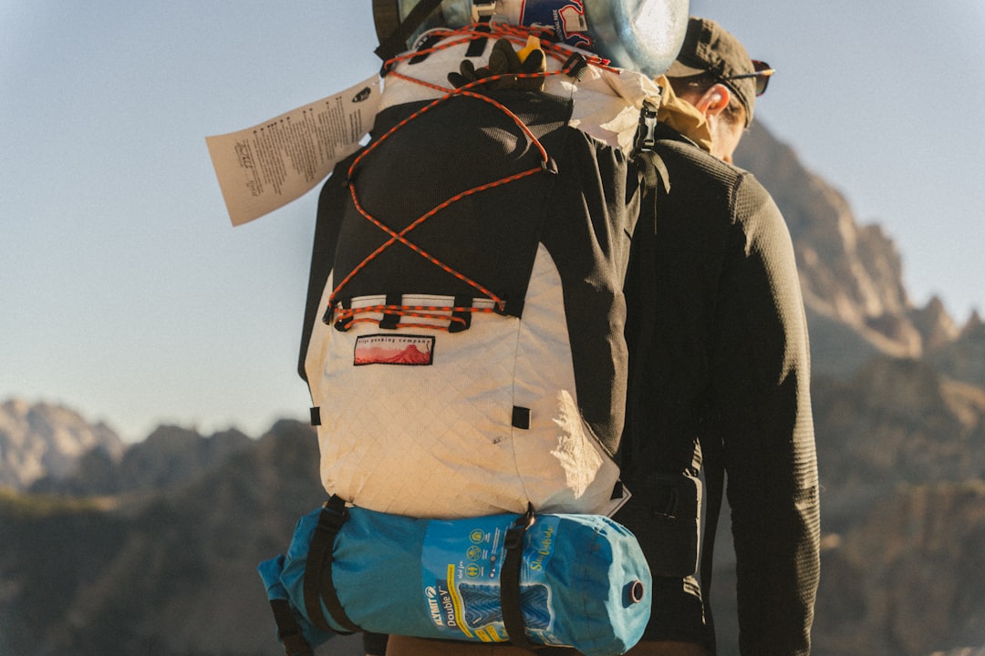 A lifestyle image showing a medium-sized Japanese cooler being carried by a camper using ergonomic h