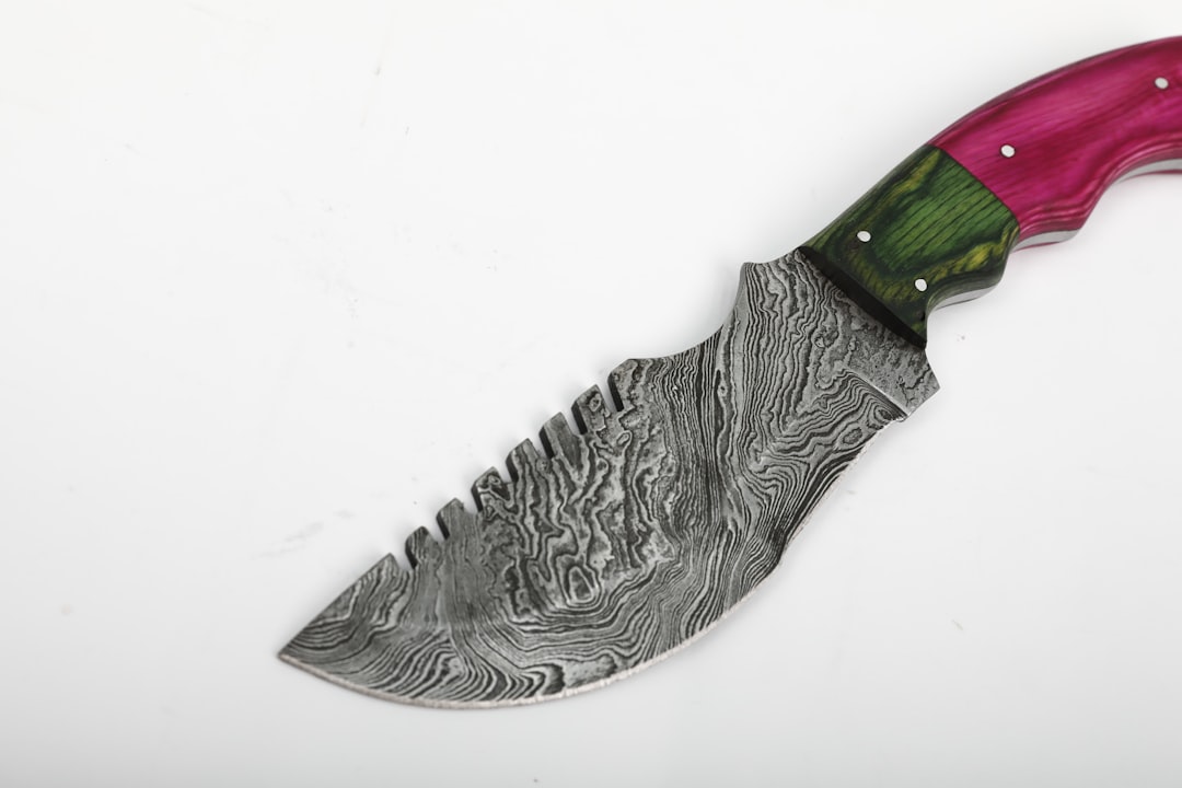 Close-up macro shot of a Miyabi knife blade showcasing the layered Damascus steel pattern and the mi
