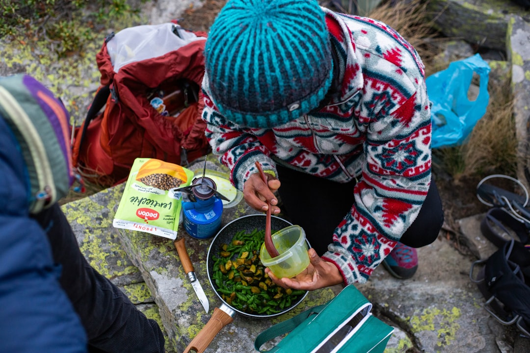 A high-quality outdoor shot featuring a camping stove in action on a rustic camp table surrounded by