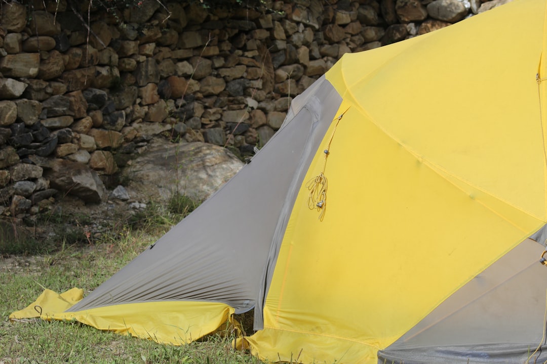 Image showing weather-specific tarp adjustments: tarp edges lowered during rain, side staked tightly