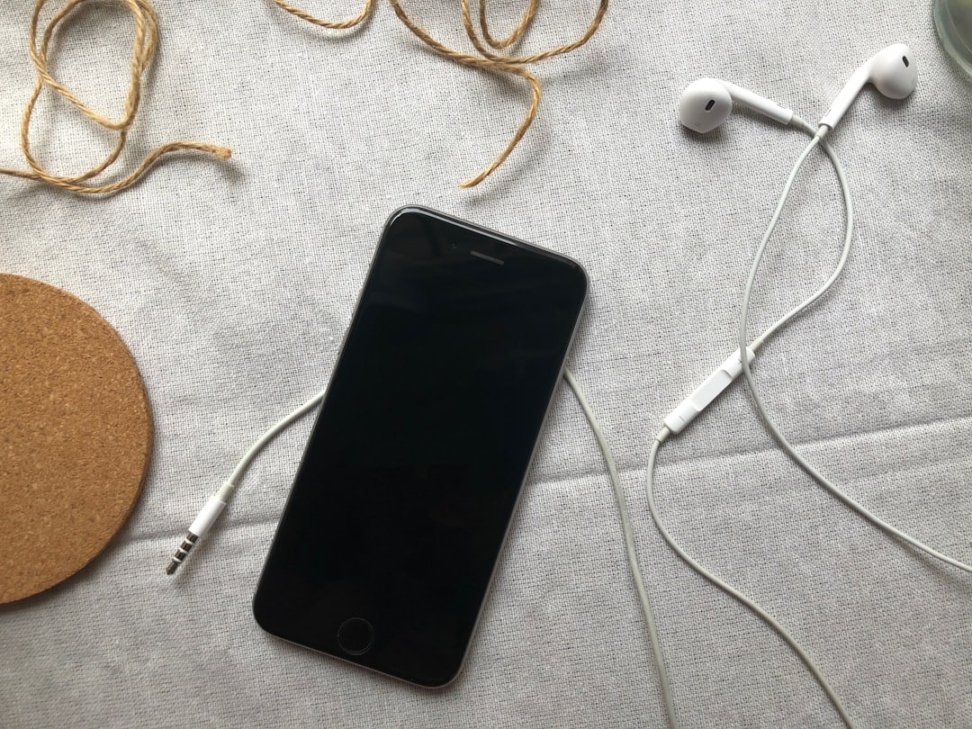 Compact lifestyle shot of the Audio-Technica ATH-SR50BT headphones folded next to a smartphone and b