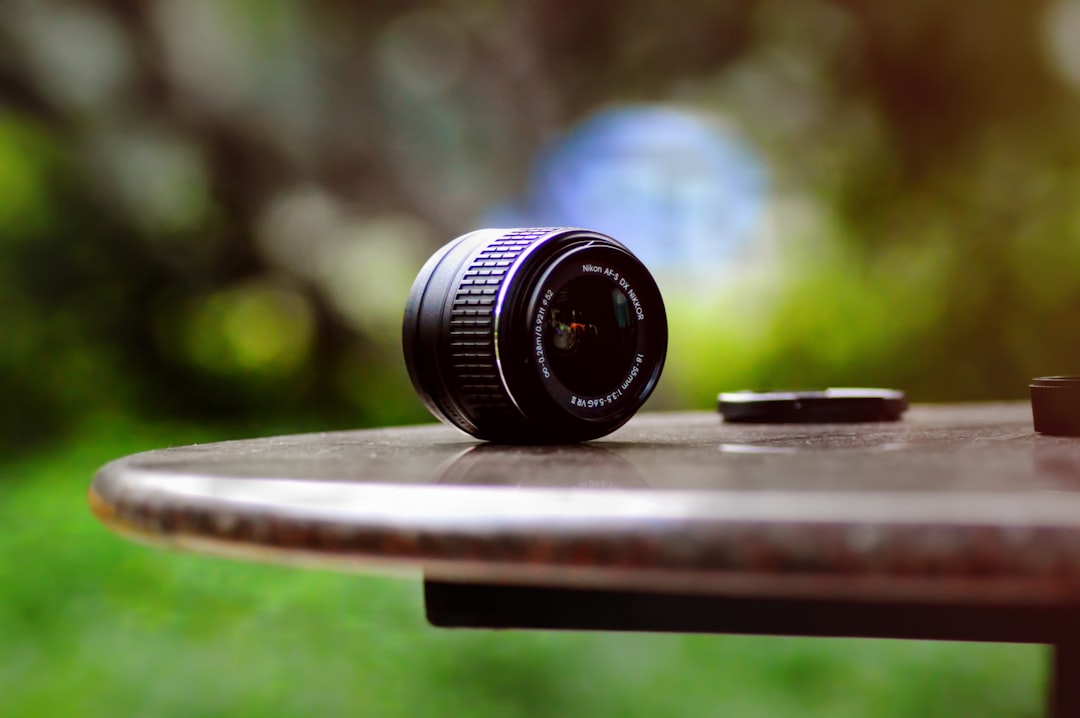 Photo showcasing a set of Olympus M.Zuiko Pro lenses alongside an Olympus camera body on a wooden ou