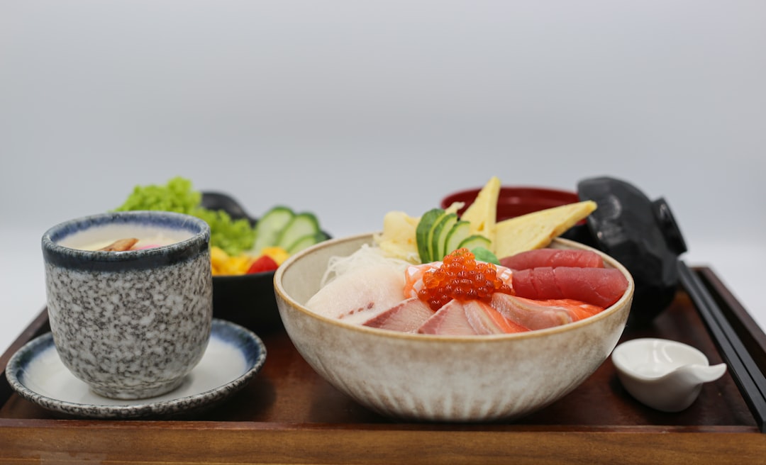 A beautifully styled overhead shot of a bowl of perfectly cooked, shiny sushi-grade rice next to a Z