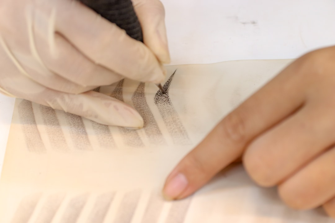 Close-up image showing hands tearing and applying textured washi tape onto a journal page, demonstra