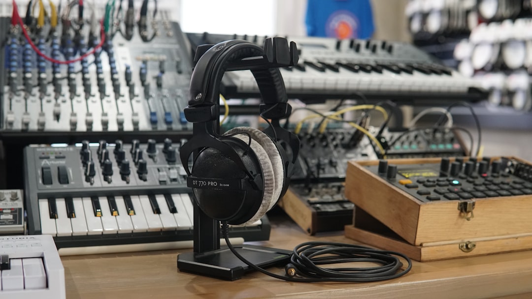 Image showing Audio-Technica ATH-M50x headphones on a studio desk with mixing console in the backgro