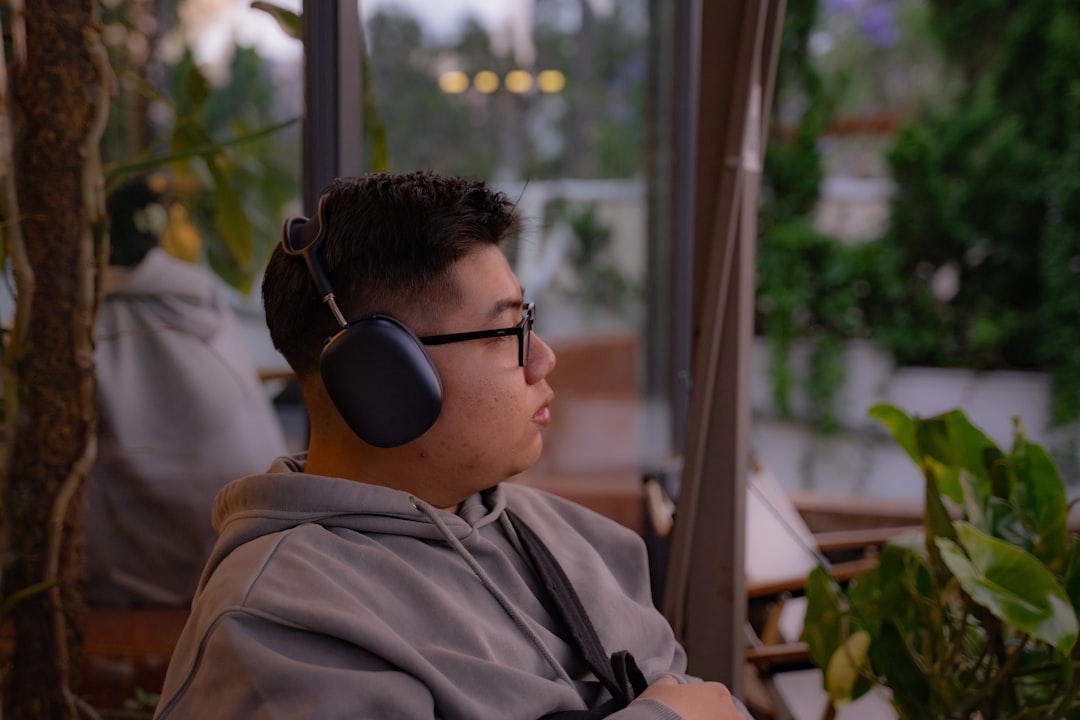 Lifestyle image showing a person comfortably wearing Panasonic RP-HTX90N over-ear wireless headphone