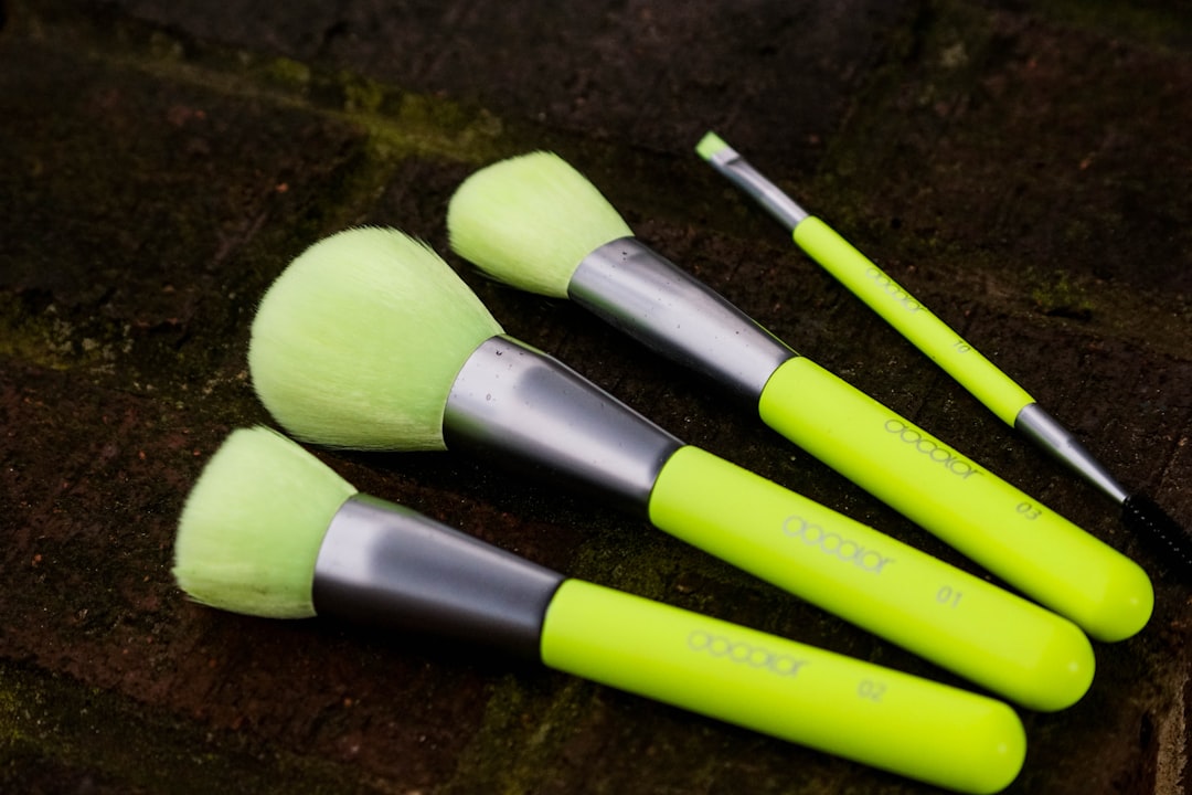 Close-up image showcasing a hand holding one of Muji’s natural hair makeup brushes applying makeup,