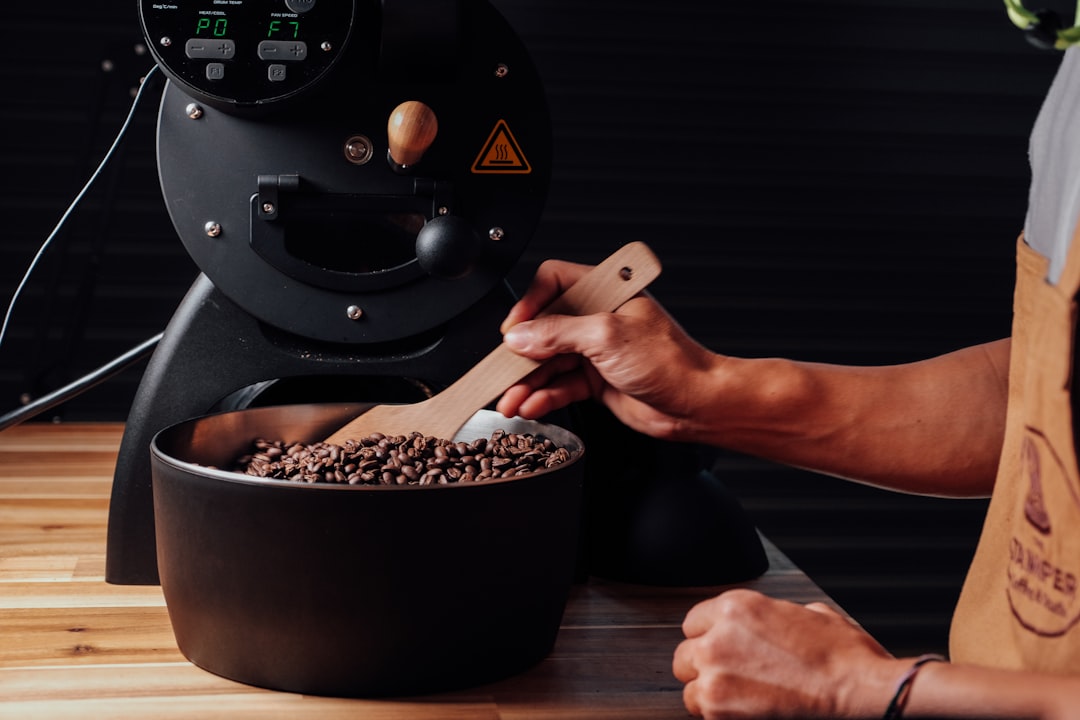 Photo of the Hario Skerton hand grinder being used by a person grinding coffee beans, emphasizing po