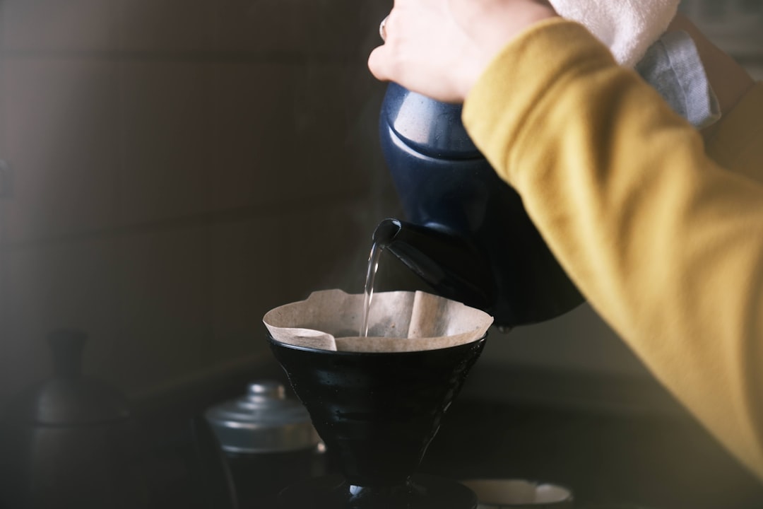 A beautifully styled overhead shot of a Hario V60 drip coffee setup in use: the glass V60 dripper on