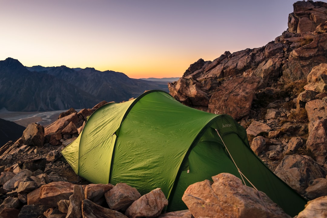 Hero image showing an American hiker setting up camp in a scenic mountainous or forested Japanese la