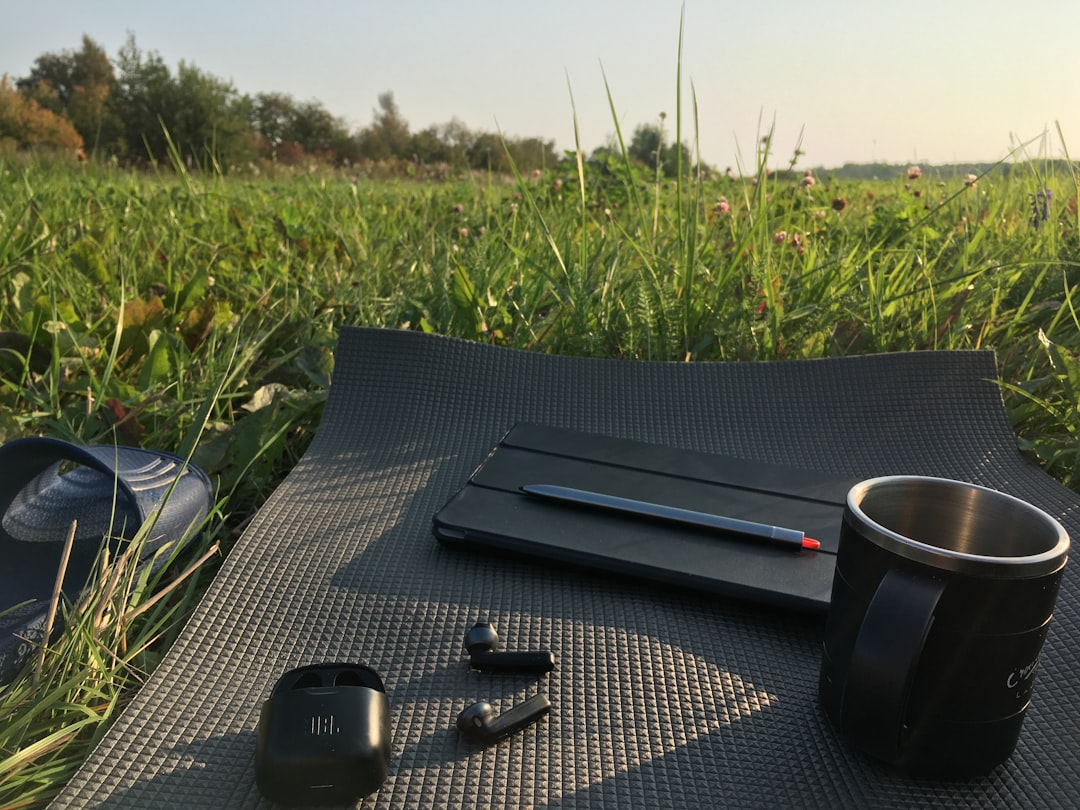 A lifestyle image showing an outdoor journaling scene: an open notebook on a rustic wooden table out