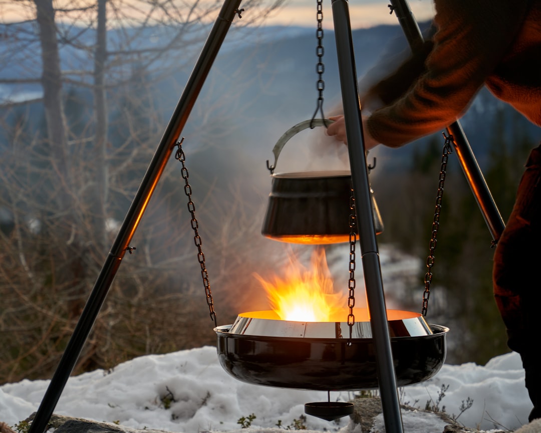 Lifestyle image of a camper or outdoor enthusiast cooking rice using the Snow Peak Field Cooker Pro.