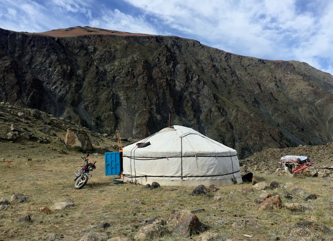 Image of a solo hiker setting up the ultra-light Snow Peak Take! Tent in a rocky, open alpine settin