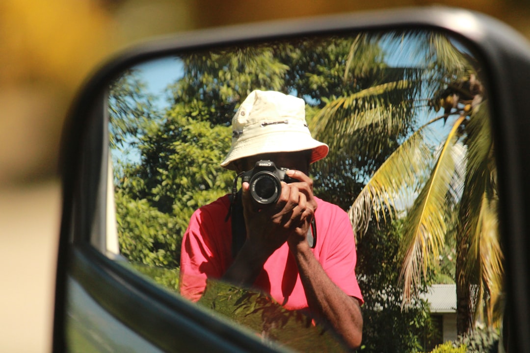 A dynamic travel photography scene featuring a person using a mirrorless camera (Olympus or Fujifilm