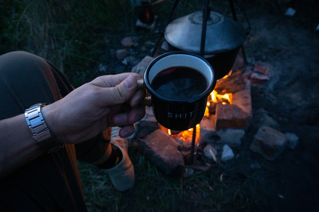 Close-up image of the Hario V60 coffee dripper in use outdoors, showing fresh coffee dripping into a