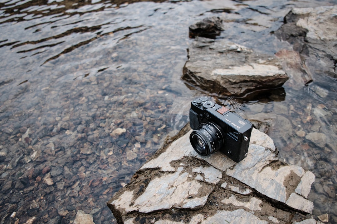 Action shot of the Olympus Tough TG-6 rugged camera being used underwater or on a rugged trail, emph
