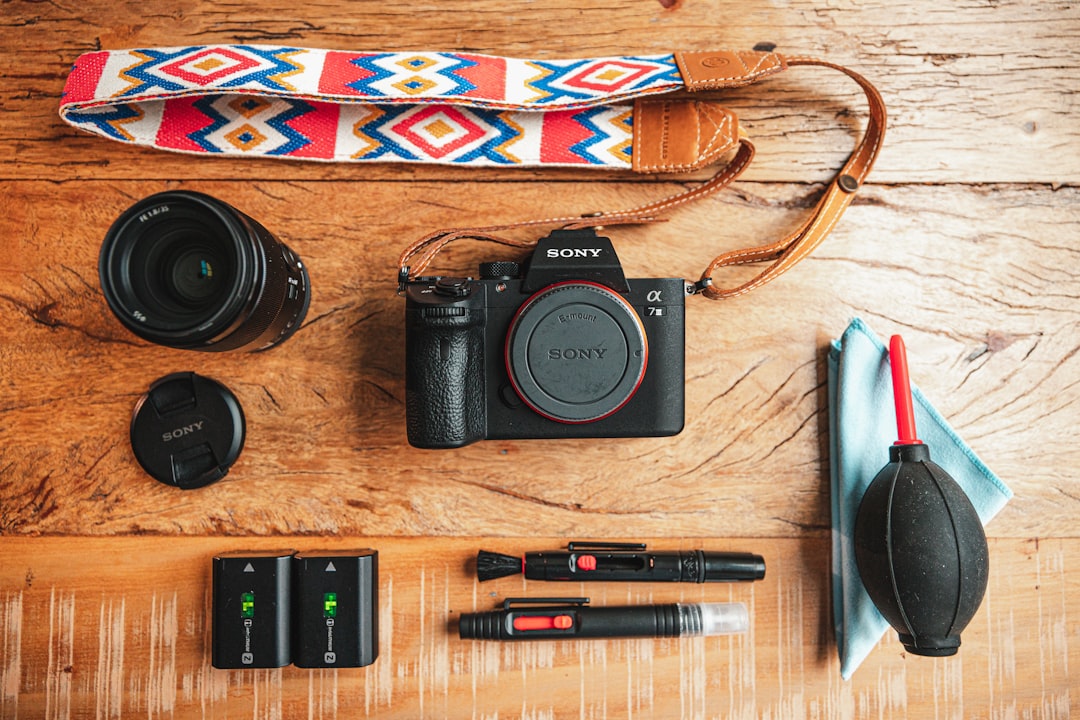 Side-by-side flat lay image of the OM SYSTEM PEN-F and Sony Alpha a6400 cameras, highlighting their 