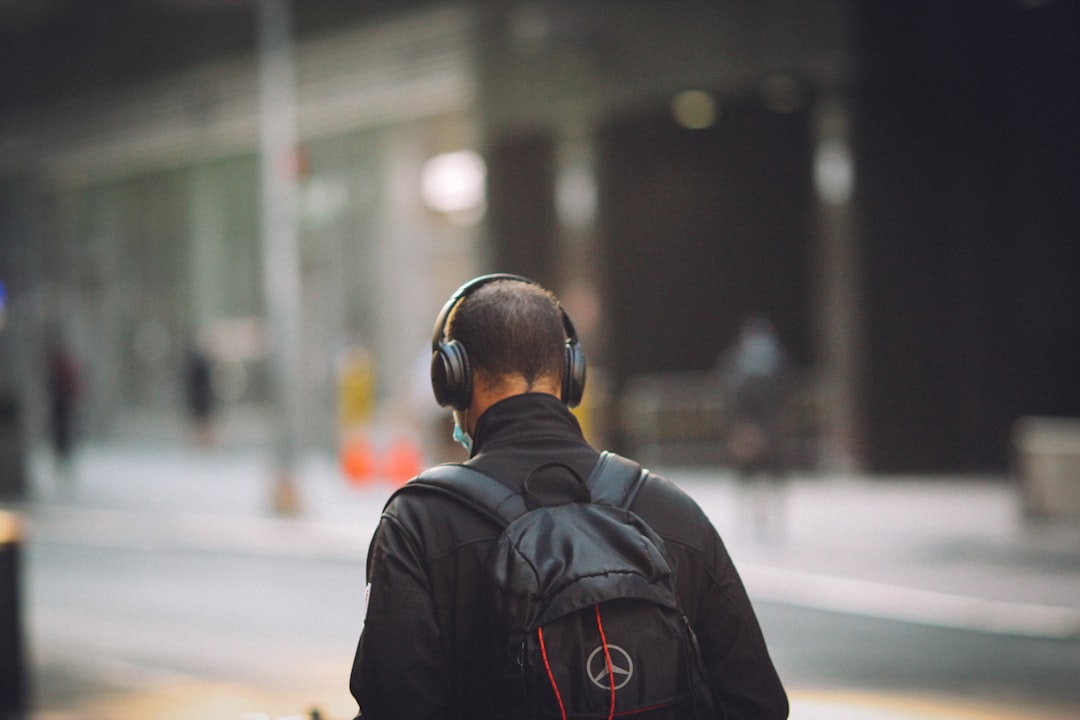 A high-quality hero image showing a stylish traveler wearing premium noise-cancelling headphones (pr